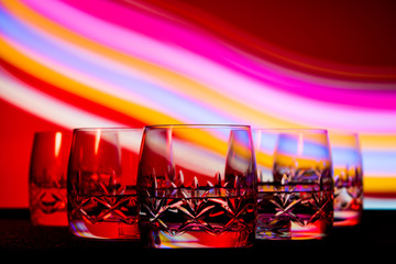 glasses in the multicolored light of the club.