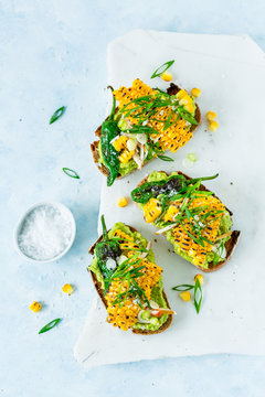 Sandwiches with avocado, smoked chicken, padron peppers, grilled corn and green onions