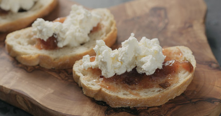 bruschetta with ricotta and fig marmalade on olive board