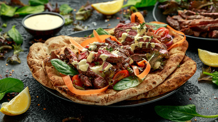 Grilled and sliced beef steak on garlic and coriander naan bread with carrot and spinach salad drizzled with home made mayonnaise sauce