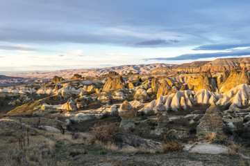 Rocky landscape of Kiliclar valley with many colorful taxtures during sunset with no people and balloons. Geological formations of Cappadocia.