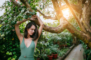woman in green swimsuit, good-looking lady merges with wildlife and looks organically around plants...