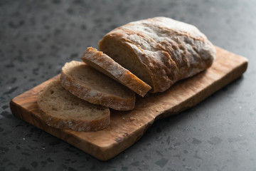 Sliced rustic style ciabatta with rye flour on olive board