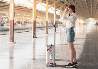 Asian young woman standing alone, Pretty girl smiles and happy for the holiday trip,Train station...