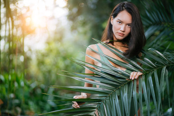 woman in green bikini, good-looking lady merges with wildlife and looks organically around plants...