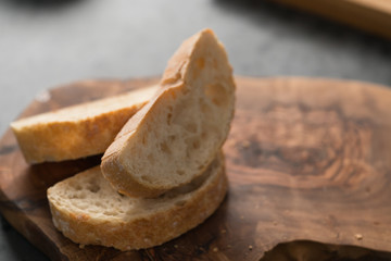 Slices of ciabatta bread on olive board
