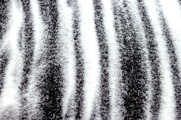 Abstract wallpaper stripe design of white color shiny snow dust powder isolated on black background