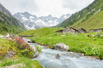 Obraz premium Almhütten mit Gebirgsfluß im Zillertal und Gletscher im Hintergrund