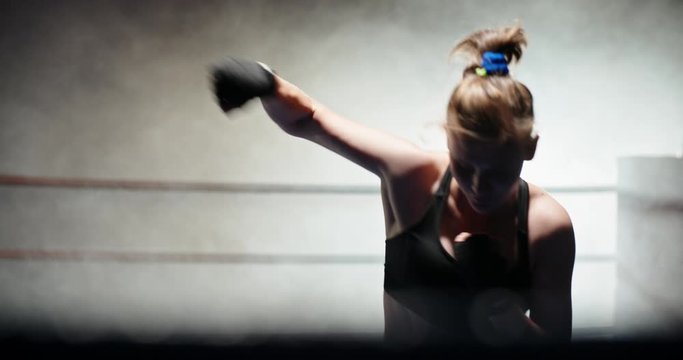 Caucasian female athlete doing a shadow fight in boxing ring, training, preparing for a tournament - fitness, sports concept 4k footage