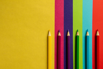 colored pencils lie on colored paper.