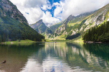 Stunning panorama view of Alpstein massif with Santis (Saentis) on Seealpsee lake side on a sunny summer day, with blue sky cloud, Canton of Appenzell, Switzerland