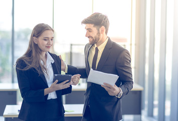 Obraz premium The young manager is talking to the female secretary in the office. Concept. Business and teamwork