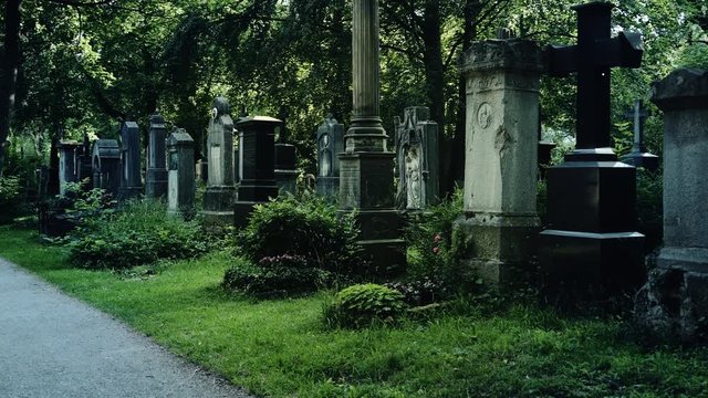 Mysterious Walk around graves in European old cemetry. The concept of horror and suspense