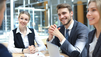 Startup business team on meeting in modern bright office interior and working on laptop.