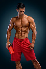 Fototapeta na wymiar Nutritional Supplement. Muscular Men Drinks Protein, Energy Drink After Workout. Copy Space