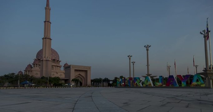 the colorful city sign of the city of Putrajaya, Malaysia. A sunrise pan time lapse the Putra Mosque or Masjid Putra, the principal mosque of Putrajaya Wilaya in the background. time lapsing malaysia