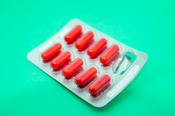 red pills in blister packs on green background