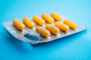 yellow pills in blister packs on blue background