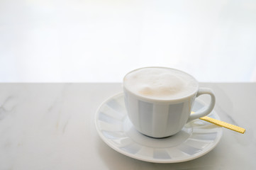 Cappuccino white cup on white table with white curtain