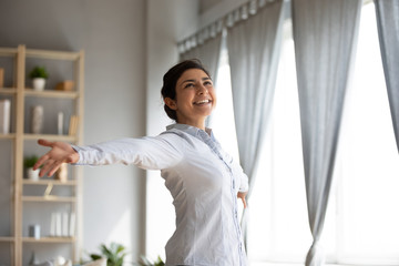 Overjoyed ethnic girl have fun dancing at home