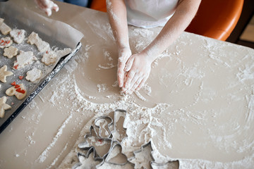 little hands kneading dough in the kitchen, close up cropped photo. child playing with flour while mother cooking dessert