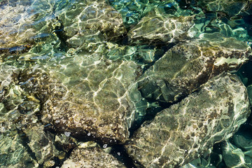 Transparent sea water and rocks underneath 