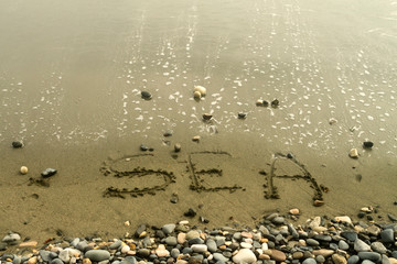 Word Sea written on beach