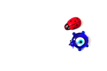 Fototapeta premium ladybug and evil eye bead on a white background, close up ladybug, evil eye bead and luck