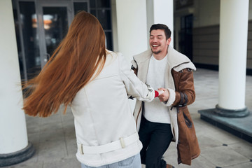 cheerful happy young people in fashion coats having fun in the street. close up photo. entertainment. laugh, fun, funny moments in life, couple celebrating an event, craziness