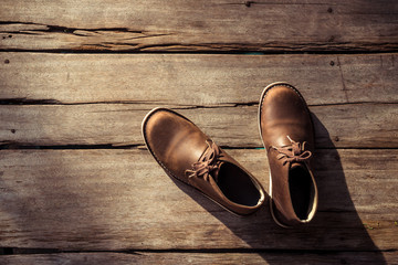 Brown stylish boots on wood background,  retro color