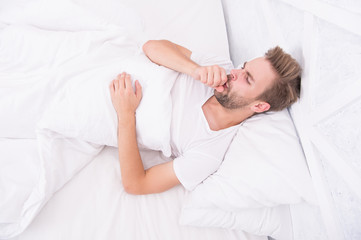 Handsome man relaxing in bed. Snoring can increase risk headaches. Common symptom of sleep apnea. Causes of early morning headache. Migraine headaches. Sleep problems can lead to headaches in morning