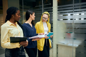 three beautiful business women walking in the office and discussing project, idea, plan. close up side view photo. copy space. conversation