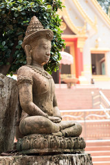 Buddha statue in front of entrance to Buddhist temple, Thailand.