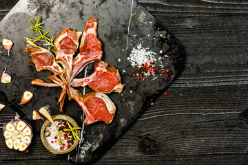 Raw lamb chops on black background