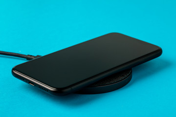 The smartphone is charged by a wireless charger  Concept of new technologies.