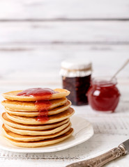 Tasty breakfast. Pancakes with strawberry confiture and butter.