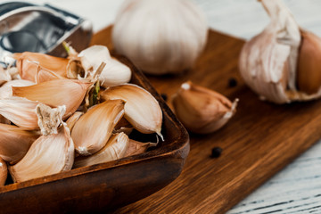Garlic on a rustic table in a wooden bowl. Fresh peeled garlic.