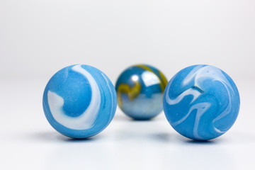 Fototapeta premium group of opaque glass marbles in blue with white and green swirls