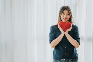 Happy Asian woman holding red heart