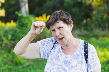 Portrait of senior woman acting crazy outside