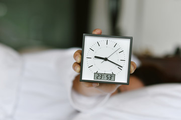 Sleepy girl's hand showing alarm clock and waking up late in the morning, Woman sleep in and laying...