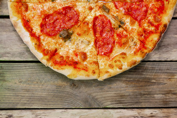 Top view of a pizza on a wooden background