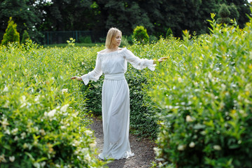 blonde in white dress posing in green