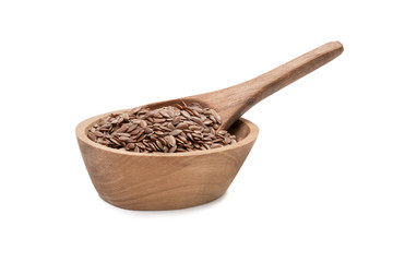 Linseeds or flax seed in a small oval wooden bowl with a spoon seen directly from the side and isolated on white background