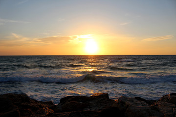 Obraz premium sunset at the rocky beach of Tel Aviv with unsettled waves