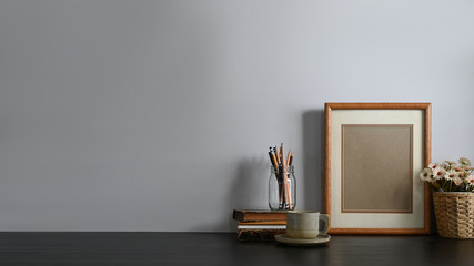 Workspace pencil holder, Stack of books, Picture frame, Coffee cup and potted flower putting...