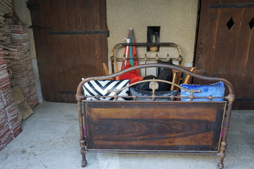 outdoor patio of a house with an old wooden couch, pillows and more