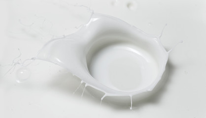 Obraz na płótnie Canvas Fresh milk pouring making a crown splash in a milk pool. Top view, isolated on grey-white background.