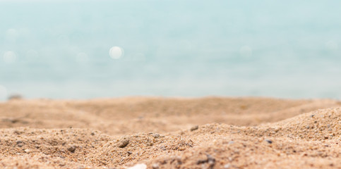 Close up surface of sand on the beach and blur foreground and blur bokeh sea background