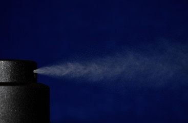 spray deodorant on a blue background